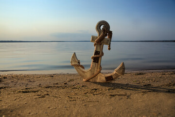 Wooden anchor on river shore near water © New Africa