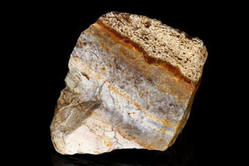 Sample of raw flint with stripes of different shades on a black background close up