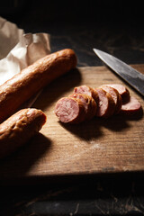 smoked beef or pork sausage on old chopping board with knife