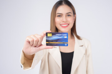 Portrait of Young beautiful woman in suit holding credit card over white  background in studio.