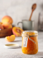 Peach jam on a light background. Copy space, vertical photo.