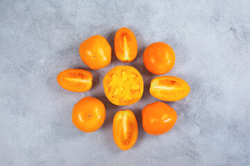 Ripe fresh yellow orange tomatoes on light gray background.
