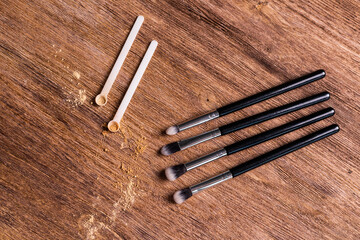 Mineral powder for face and a brushes for powder and visage on wooden background. Eco friendly and organic cosmetics.