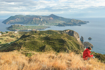 Junge Frau genießt den Ausblick auf Lipari und Vulcano im tyrrhenischen Meer  © ARochau