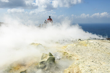 Wanderer mit Mundschutz durchquert Schwefeldampfwolken am Krater des Vulcano  © ARochau