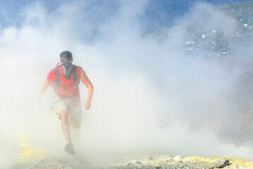 Wanderer mit Mundschutz durchquert Schwefeldampfwolken am Krater des Vulcano  © ARochau