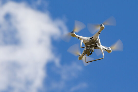 a white drone taking images in the air