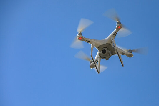 a white drone taking images in the air