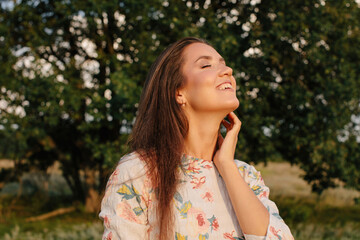 Summer portrait of happy woman with long hair posing with closed eyes  - 455219522