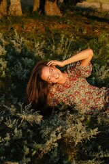 Smiling woman with closed eyes in summer field in flowers pattern dress  - 455219701