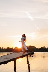 dancing woman on pier at sunset light  - 455220519