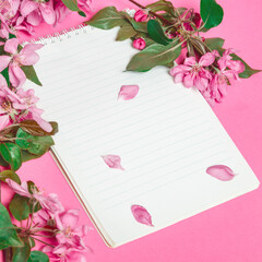 Notebook, beautiful branches of apple blossoms on white background. space for text