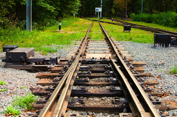 Detailed view of narrow gauge railway arrow. Kyiv Children's Railway in Syretsky Park. Important elements of railway track close-up. Nature background