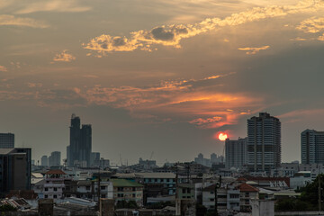 Fototapeta premium Bangkok, Thailand - 09 Apr, 2020 : Skyscrapers Bangkok City in the light of the setting sun silhouetted cities at sunset. Beautiful sunset over office building center. Selective focus.