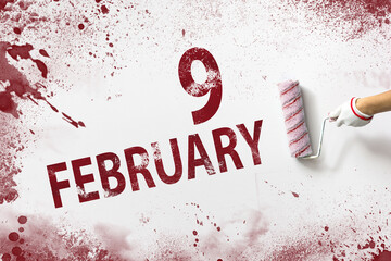 February 9th. Day 9 of month, Calendar date. The hand holds a roller with red paint and writes a...