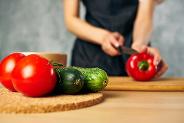 Cook woman on the kitchen cutting vegetables salad diet