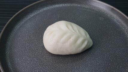 steamed fresh yellow corn custard bun white baozi in leaf shape on dark grey wood background dim sum halal menu