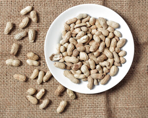Raw peanuts. Peanuts that grow into the ground and leaves appear on the surface of the soil. This type of bean grows in the soil and belongs to the legume group. Peanut mockup. Focus blur.