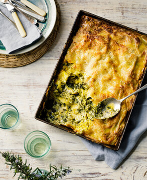vegetarian lasagne with silverbeet and pumpkin in a tray on table with dinnerware