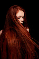 Redhead girl with long hair contrast art portrait. Perfect woman on black background. Gorgeous hair...
