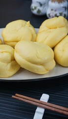 steamed fresh yellow pumpkin bun mantou on dark grey wood background dim sum halal menu