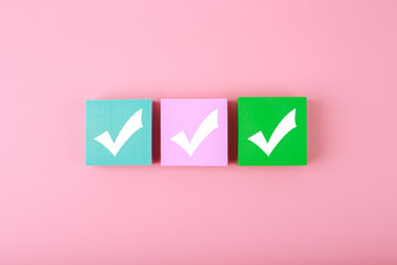 Three checkmarks top view on bright pastel pink  background with copy space. Concept of...
