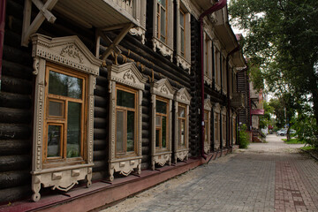 an old house, cobblestone walls, windows with decorative trim. wooden architecture.
