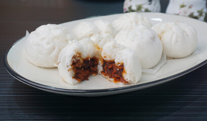 steamed fresh char stew marinated pork belly bun white baozi on dark grey wood background Hong Kong dim sum menu