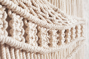 Close-up of hand made macrame texture pattern. ECO friendly modern knitting DIY natural decoration concept  in the interior.  Handmade macrame 100% cotton. Female hobby. - obrazy, fototapety, plakaty