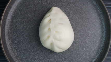 steamed fresh vegetables bun white baozi in leaf shape on dark grey wood background dim sum halal menu