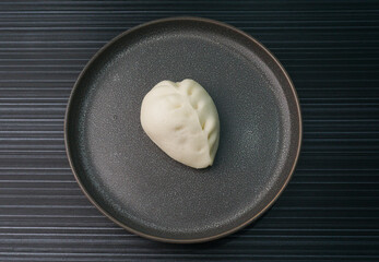 Chinese Hong Kong steamed fresh mixed vegetables carrot bun vegan white bao zi in leaf shape on dark grey wood background asian dim sum halal food restaurant cuisine banquet menu for cafe