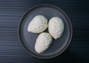 steamed fresh vegetables bun white baozi in leaf shape on dark grey wood background dim sum halal...