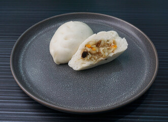 Chinese Hong Kong steamed fresh mixed vegetables carrot bun vegan white bao zi in leaf shape on...