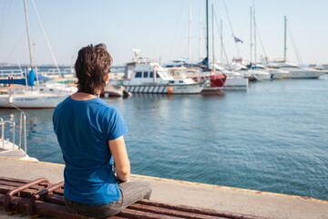 Fototapeta premium Tourist in seaport. Yachts in the parking lot, seaport in Odessa, Black Sea. Sailing, rich lifestyle, beach holidays. Business rental of boats, riding tourists on waves. sunny day, wind. portrait