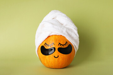 Spa concept with pumpkin on green background - obrazy, fototapety, plakaty
