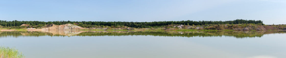 Fototapeta na wymiar Wide panorama of lake on-site of abandoned ilmenite quarry