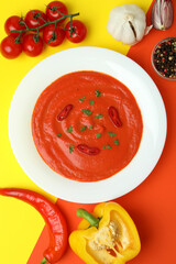 Gazpacho soup and ingredients on two tone background