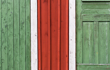 Fototapeta na wymiar Rote und grüne Hausfassade aus Holz. Schwedisches Haus. Hintergrund. Red and green wooden house facade. Swedish house. Background.