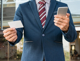 Businessman showing blank business card and holding smart phone..Business man holding white blank card space for text. product display montage.
