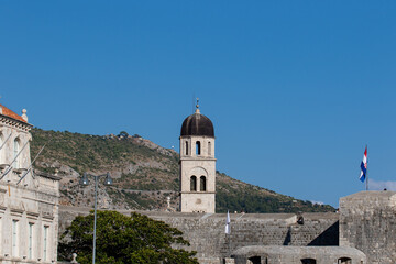 Bell tower on Stradun street on a sunny cloudless day, in Dubrovnik, Croatia. Croatian architecture, stone building