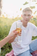 Young couple having picnic on sunflower field at sunset