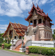 Obraz premium Landscape view of ancient Hor Trai library with beautiful stucco bas-relief decoration at famous landmark Wat Phra Singh buddhist temple, Chiang Mai, Thailand
