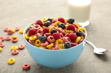 Breakfast with cereals, milk and berry on grey background.