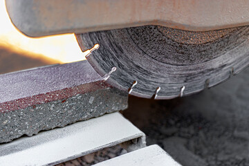 The circular diamond saw cuts concrete paving slabs. Concrete cutting machine close-up.