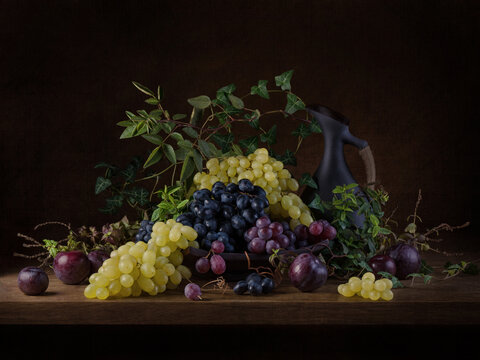 Still life with grapes and jug in dark moody style
