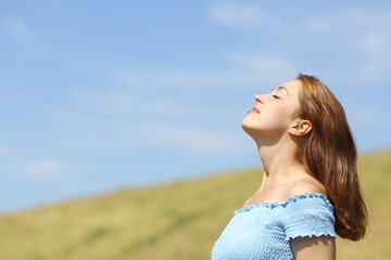 Fototapeta na wymiar Profile of a woman breathing fresh air in a wheat field