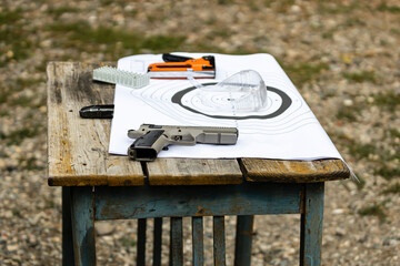 Weapon and safety gear on a table at the shooting range