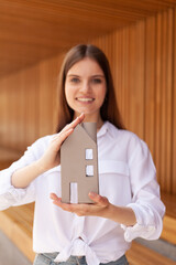 Construction company advertisement. The girl is holding a mock-up of the house..Social assistance...