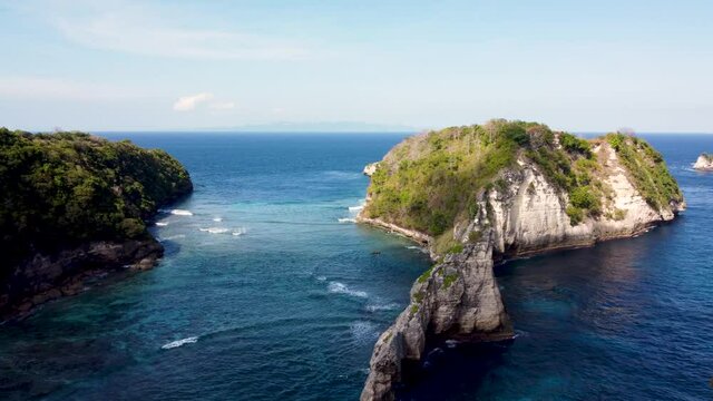 Fly around cliff and rocks over ocean along coast with amazing view on Diamond Beach, Nusa Penida, Bali, Indonesia. High quality 4k aerial footage