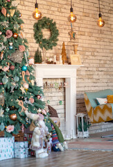 Decorated New Year's blue spruce near the Christmas fireplace with a wreath. Christmas celebration conceptSoft selective focus, art noise